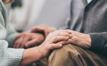 Cropped view of retired couple holding hands