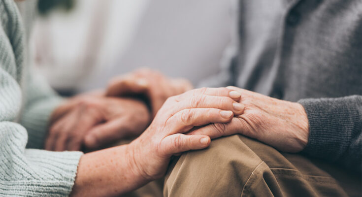 Cropped view of retired couple holding hands